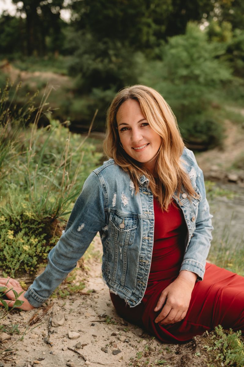 Photographer Stephanie Shanks sitting outdoors in a denim jacket
